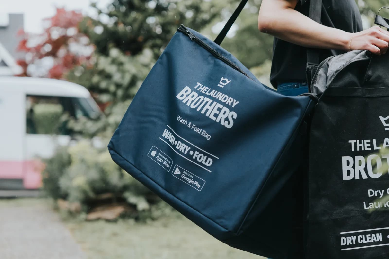 A Laundry Brothers driver delivering a wash & fold bag at a North Vancouver doorstep.