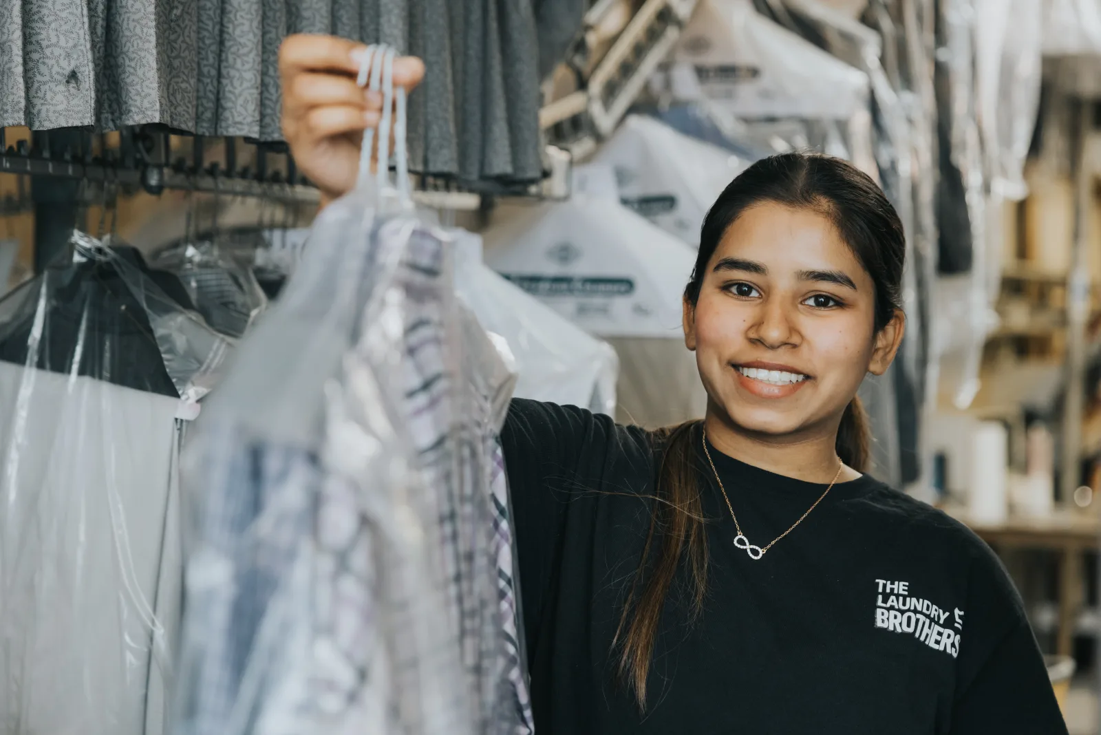 A Laundry Brothers team member with a freshly cleaned garment for a North Vancouver customer.